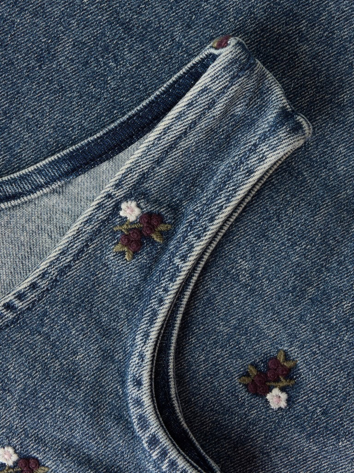 NMFROBERTA Robe chasuble en jean brodée de fleurs fille — Lil' Atelier — Dark Blue Denim — détail de la bretelle, de l'encolure et de la broderie 6 | Appart 17 Bruxelles