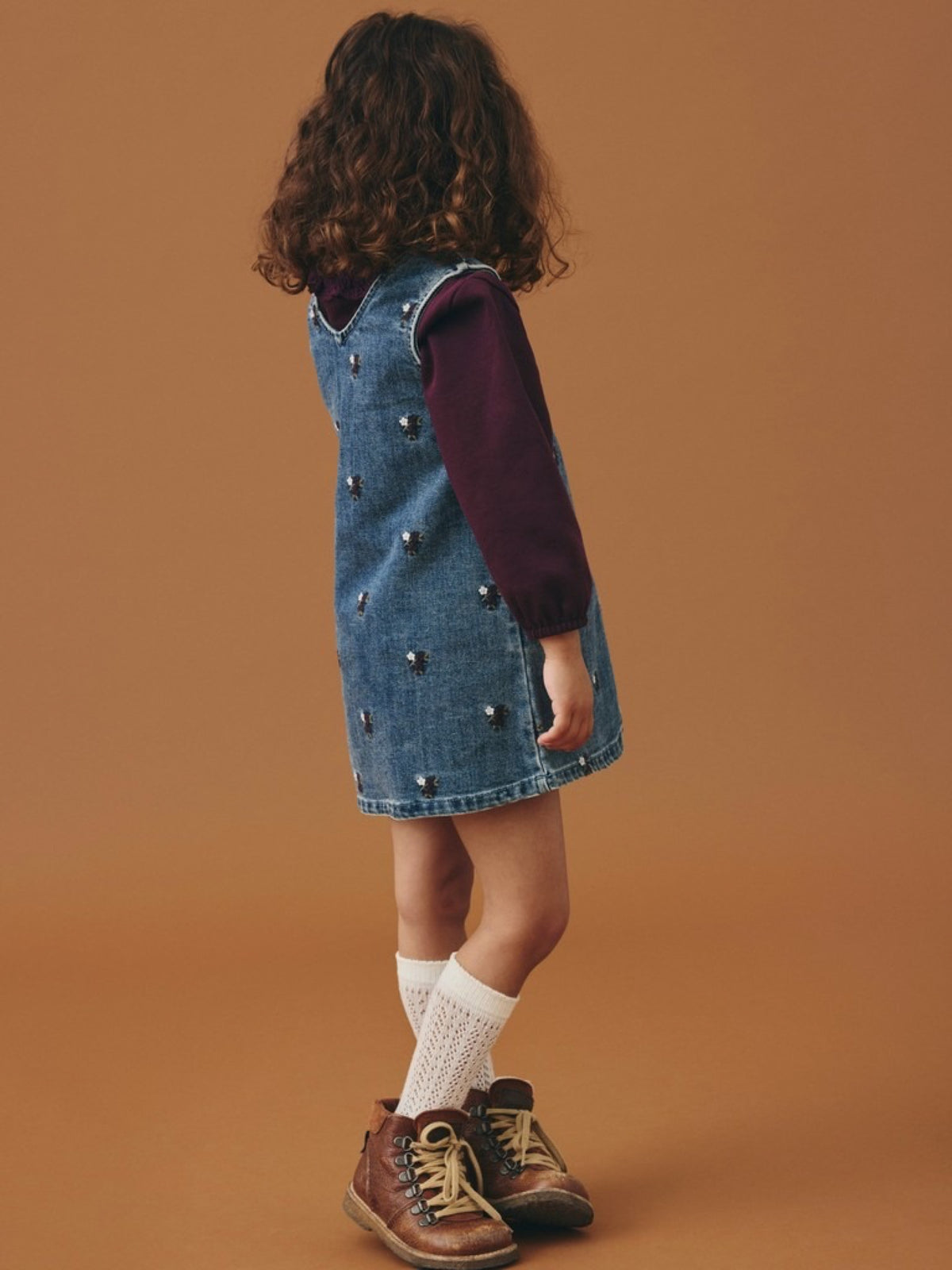NMFROBERTA Robe chasuble en jean brodée de fleurs fille — Lil' Atelier — Dark Blue Denim — portée, en pied, de dos trois quarts 2 | Appart 17 Bruxelles