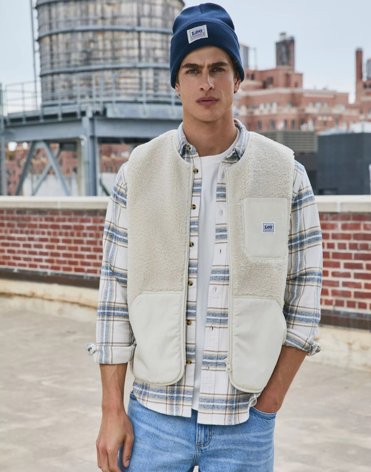 WORKWEAR Gilet sans manches zippé en sherpa, poches en toile — Lee — Warm Ecru — lifestyle, ouvert sur une chemise à carreaux 7 | Appart 17 Bruxelles