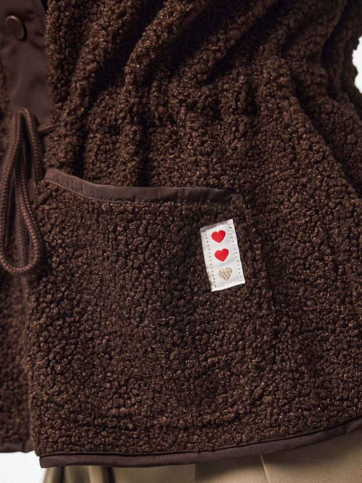 PCKATTY Gilet sans manches en teddy à col montant — Pieces — Hot Fudge — détail de la poche et de l'étiquette à cœurs 6 | Appart 17 Bruxelles