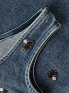 NMFROBERTA Robe chasuble en jean brodée de fleurs fille — Lil' Atelier — Dark Blue Denim — détail de la bretelle, de l'encolure et de la broderie 6 | Appart 17 Bruxelles