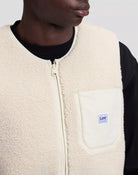 WORKWEAR Gilet sans manches zippé en sherpa, poches en toile — Lee — Warm Ecru — détail encolure, tirette Lee et poche poitrine 4 | Appart 17 Bruxelles