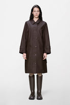 Rains NARA Long W Jacket Imperméable long cintré à capuche amovible — Rains — Bark — porté, vue de face | Appart 17 Bruxelles