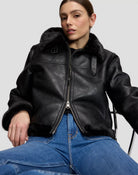 AVIATOR Blouson aviateur court femme effet cuir, col en peluche à boucle — Lee — Black — lifestyle, assise, zip ouvert par le bas 6 | Appart 17 Bruxelles