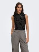 JDYFLORA Top sans manches à fleurs floquées, col montant boutonné — JDY — Black — porté, de face, avec pantalon large 2 | Appart 17 Bruxelles
