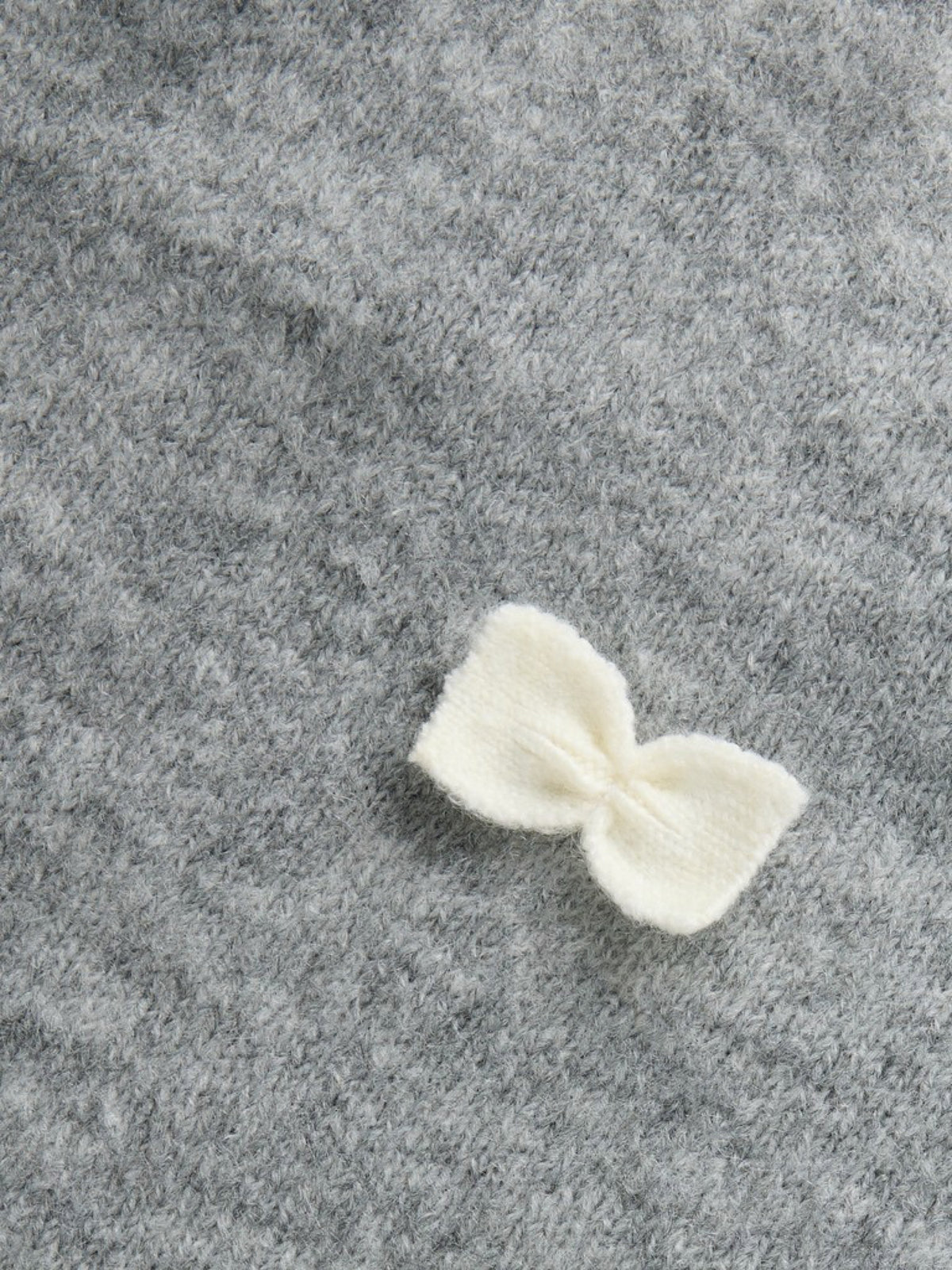 NMFRAVI Pull duveteux à petits nœuds fille — name it — Grey Melange — détail d’un nœud 5 | Appart 17 Bruxelles
