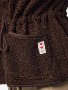 PCKATTY Gilet sans manches en teddy à col montant — Pieces — Hot Fudge — détail de la poche et de l'étiquette à cœurs 6 | Appart 17 Bruxelles