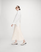 Valerie Chemise oversize en coton à nouer dans le dos — Grace & Mila — Ivoire — Portée en pied de profil, en marche : volume oversize, poignet boutonné et fente du dos 4 | Appart 17 Bruxelles